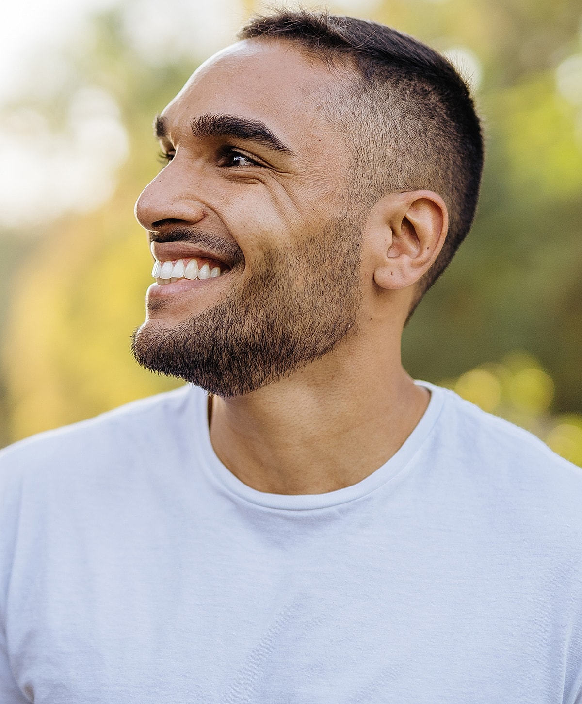 Smiling man outdoors with short hair and beard.
