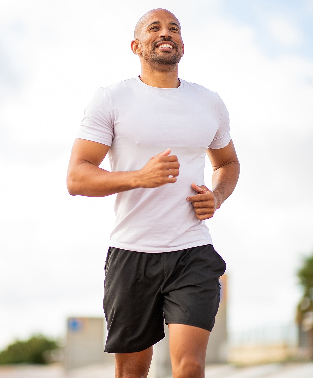 Man jogging outdoors with a smile.