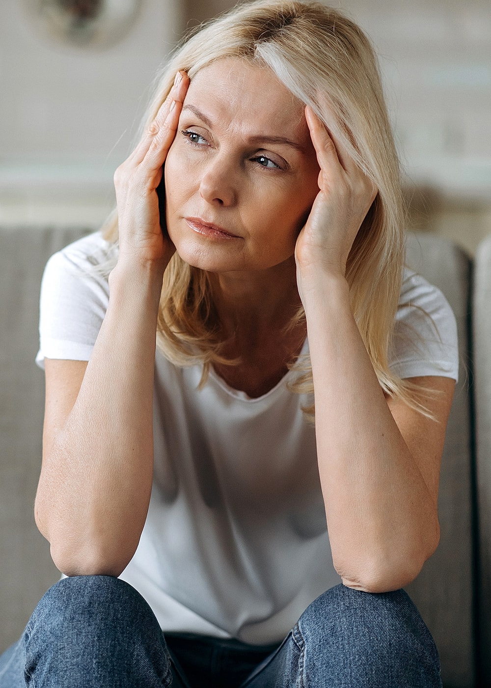 Woman with a distressed expression, holding her head.