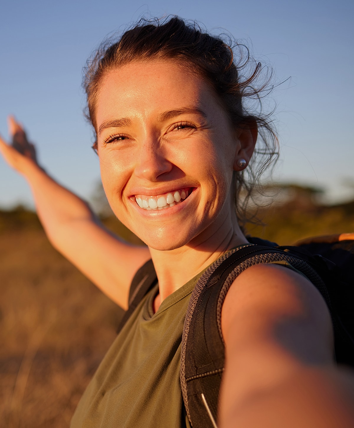 Smiling woman enjoying outdoor adventure at sunset.