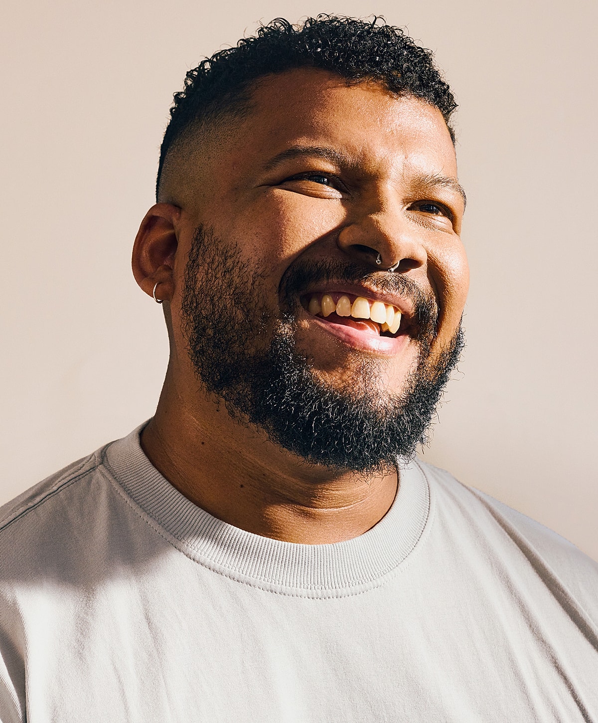 Smiling man with curly hair and beard.