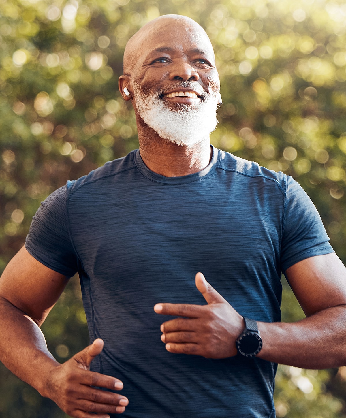 Smiling man jogging outdoors in sports attire.